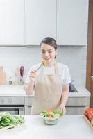 mooi vrouw aan het eten een salade in de keuken foto