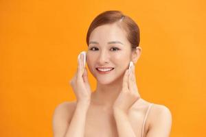 gelukkig glimlachen mooi Aziatisch vrouw gebruik makend van katoen stootkussen schoonmaak huid foto