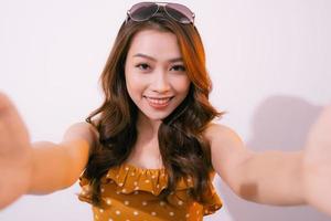 jong vrouw staand geïsoleerd Aan pastel achtergrond nemen selfie foto Aan smartphone poseren naar camera glimlachen toothy detailopname