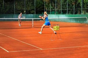 twee jong Dames spelen tennis buitenshuis Aan twee jong vrouw spelen tennis foto