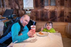 vader zijn weinig zoon aan het eten een pizza foto