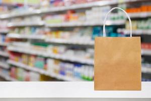 papier zak Aan apotheek apotheek teller tafel met geneeskunde en gezondheidszorg Product Aan schappen vervagen achtergrond foto