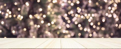 leeg hout tafel top met abstract vervagen Kerstmis boom met decoratie bokeh licht achtergrond voor Product Scherm foto