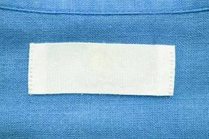 wit blanco kleding label etiket Aan blauw linnen overhemd kleding stof structuur achtergrond foto