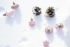 Kerstmis - kerstballen versierd, roze Kerstmis ballen, pijnboom en sneeuwvlokken in sneeuwen achtergrond foto