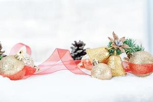 Kerstmis van winter - Kerstmis ballen met lint Aan sneeuw, winter vakantie concept. Kerstmis rood ballen, gouden ballen, pijnboom en sneeuwvlokken decoraties in sneeuw achtergrond foto