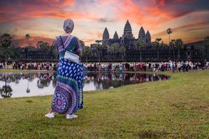 toerist vrouw aan het kijken zonsopkomst Bij Angkor wat tempel siem oogsten Cambodja. foto