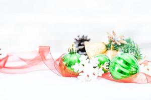 Kerstmis van winter - Kerstmis ballen met lint Aan sneeuw, winter vakantie concept. Kerstmis groen ballen, gouden ballen, pijnboom en sneeuwvlokken decoraties in sneeuw achtergrond foto