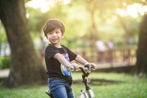 Bangkok Thailand - okt 09, 2016 gelukkig vrolijk kind jongen rijden een fiets in park in de natuur foto