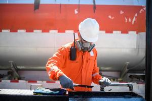een Mens werken in een olie veld- en hij is controle of inspecteren de olie. foto