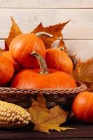 gelukkig dankzegging dag. rijp oranje pompoenen, tarwe en maïs Aan bruin houten achtergrond. foto
