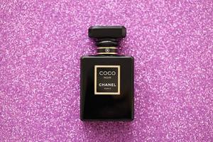 ternopil, Oekraïne - september 2, 2022 kokosnoot noir chanel Parijs wereldwijd beroemd Frans parfum zwart fles Aan glimmend schitteren achtergrond in Purper kleuren foto