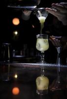 barman mengsels mooi cocktail in een glas foto