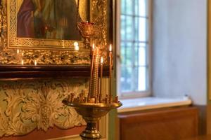 orthodoxe kerk. Christendom. feestelijke interieurdecoratie met brandende kaarsen en icoon in traditionele orthodoxe kerk op paasavond of kerstmis. religie geloof bidden symbool. foto