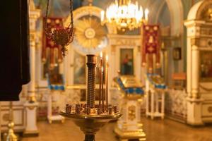 orthodoxe kerk. Christendom. feestelijke interieurdecoratie met brandende kaarsen en icoon in traditionele orthodoxe kerk op paasavond of kerstmis. religie geloof bidden symbool. foto