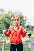 vrouw in fitness kleding doen oefeningen in het park foto