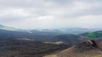 wolken over- zwart lava veld- Aan monteren Etna foto