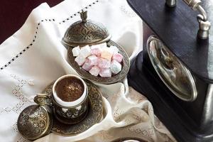 Turkse koffie met verrukking en traditionele serveerset, vintage klok foto