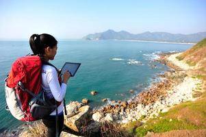 wandelende vrouw gebruik tablet pc aan zee