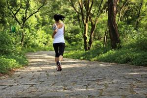 jonge fitness vrouw draait op bos stenen parcours