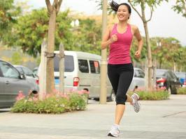 sport Aziatische vrouw joggen in het stadspark foto