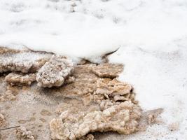 stukken van natuurlijk zout in schuim van dood zee foto