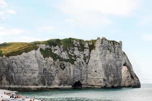 mensen Aan strand in de buurt krijt klif in etretat foto