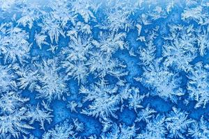 sneeuwvlokken en vorst Aan venster in winter dichtbij omhoog foto