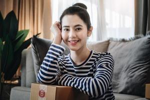online verkoop bedrijf idee, mooi meisje glimlachen gelukkig van verkoop producten online van huis. foto