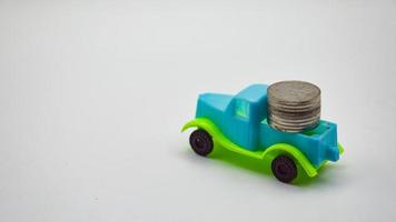 zilver munten gestapeld Aan een blauw groen vrachtwagen. wit achtergrond concept auto verzekering het beleid financieel bedrijf foto