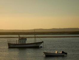 boten Aan de kust Bij zonsondergang foto