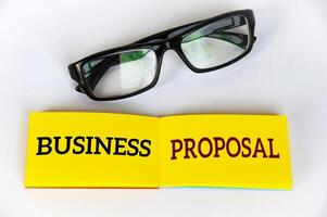 top visie van bedrijf voorstel tekst Aan geel kladblok met bril Aan wit Hoes achtergrond. bedrijf concept foto
