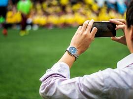 Mens in werk uniform kijk maar en schieten Amerikaans voetbal wedstrijden naast Amerikaans voetbal veld- foto