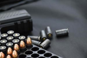 automatisch 9 mm zwart pistool met kogels, kogel schelpen Aan wazig zwart achtergrond. foto