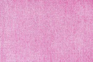 dichtbij omhoog structuur van roze grof weven bekleding kleding stof. decoratief textiel achtergrond foto