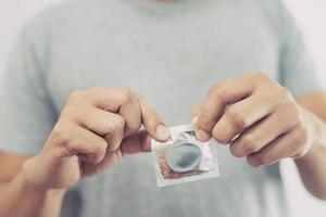 condoom klaar naar gebruik in mannetje hand, geven condoom veilig foto