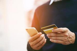 concept mannetje naar boodschappen doen handig ogenblikkelijk. klanten kan gebruik de telefoon naar boodschappen doen online bestellen aankoop verkopen en betaling met credit kaarten Doen niet hebben naar reizen hebben naar winkel op te slaan. foto