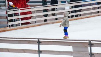 mensen hebben pret het schaatsen Aan een openbaar ijs baan gebouwd door de gemeente Aan de straten van de stad gedurende Kerstmis foto