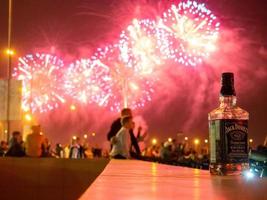 Kazan, Rusland. 08.30.2021 fles van jack Daniels whisky tegen de achtergrond van vuurwerk. vieren de dag van de cit foto