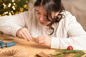 meisje maakt Kerstmis boom decoraties uit van papier met haar eigen handen. stap 3. stap voor stap instructie foto