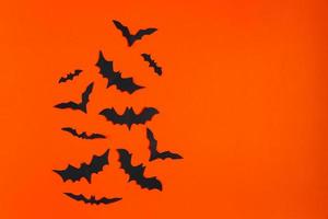gelukkig halloween. papier vleermuizen Aan oranje achtergrond. foto