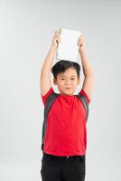 jong Aziatisch jongen leerling Holding boek en tonen over- hoofd, geïsoleerd Aan wit achtergrond foto