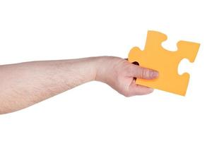 mannetje hand- Holding groot geel papier puzzel stuk foto