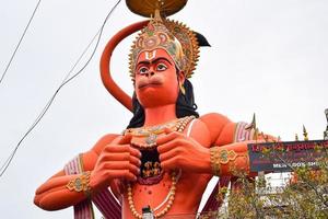 nieuw Delhi, Indië - juni 21, 2022 - groot standbeeld van heer Hanuman in de buurt de Delhi metro brug gelegen in de buurt karol zak, Delhi, Indië, heer Hanuman standbeeld aanraken lucht foto