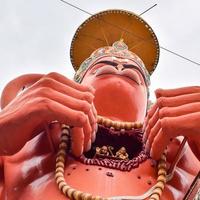 nieuw Delhi, Indië - juni 21, 2022 - groot standbeeld van heer Hanuman in de buurt de Delhi metro brug gelegen in de buurt karol zak, Delhi, Indië, heer Hanuman standbeeld aanraken lucht foto