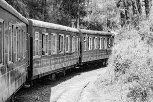 speelgoed- trein in beweging Aan berg helling, mooi visie, een kant berg, een kant vallei in beweging Aan spoorweg naar de heuvel, tussen groen natuurlijk bos.speelgoed trein van kalka naar shimla in india-zwart en wit foto