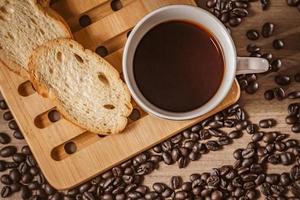 koffie Aan houten achtergrond. bruin geroosterd koffie bonen, zaad Aan donker achtergrond. espresso donker, aroma, zwart cafeïne drankje. detailopname geïsoleerd energie mokka, cappuccino ingrediënt. foto