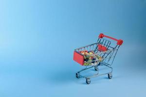 kopen geneesmiddel. boodschappen doen mand met divers geneeskrachtig, pillen, tablets Aan blauw achtergrond. studio foto