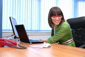 glimlachen jong zakenvrouw werken Aan een laptop in de kantoor. foto