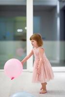 schattig weinig meisje spelen met ballonnen foto